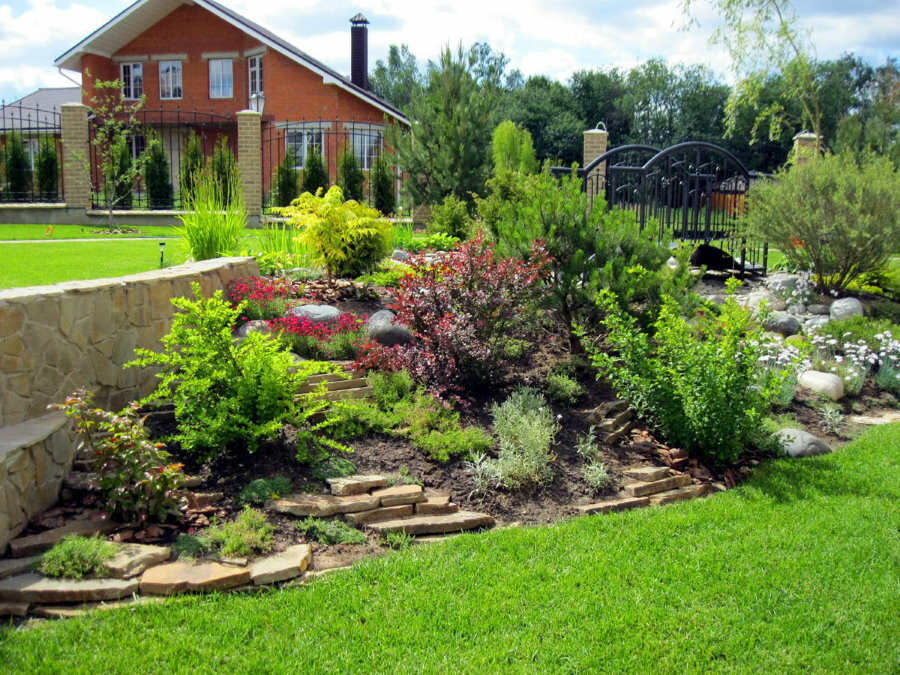 Rock garden on a plot with a green lawn