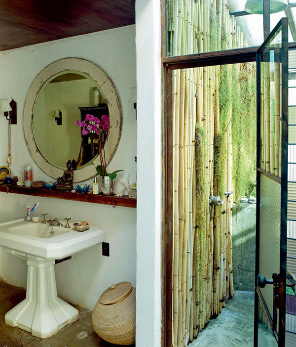 A fürdőszobában egy nagy kerek tükör lóg antik keretben.