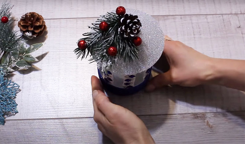 Díszítse a zseblámpa kupakját karácsonyi játékkal, szál fenyőtűvel és gyöngyökkel