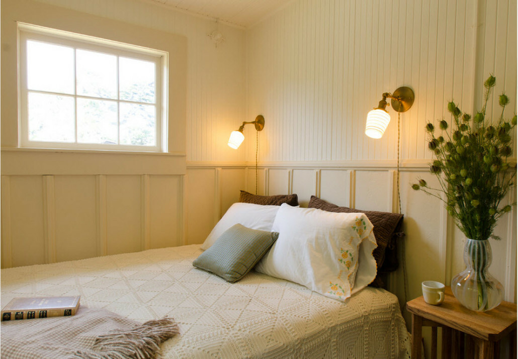Compact sconces above the bed in the bedroom