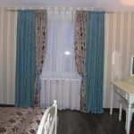 Grå-blå gardiner og sengeteppe på sengen i soverommet