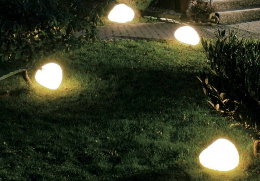 Gece bahçesinde aydınlatılan yapay taşlar