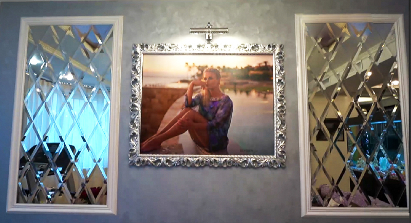 A foto de Anna é iluminada por um lustre de parede moderno e elegante em uma caixa de metal cromado