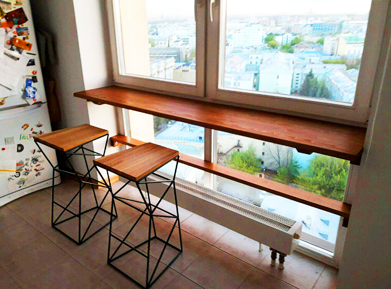 O peitoril da janela na varanda também pode ser expandido e transformado em uma mesa conveniente, e se você instalar prateleiras abertas na lateral, poderá transferir toda a biblioteca doméstica para a varanda