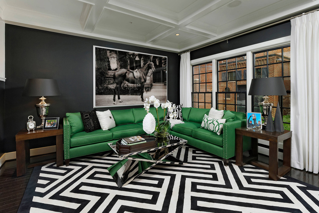 Sofá de cuero verde en un salón con una pared negra