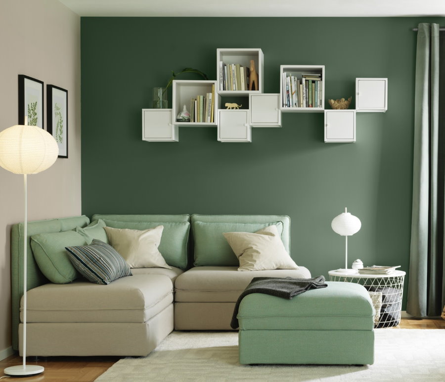 Valged riiulid elutoa rohelisel seinal