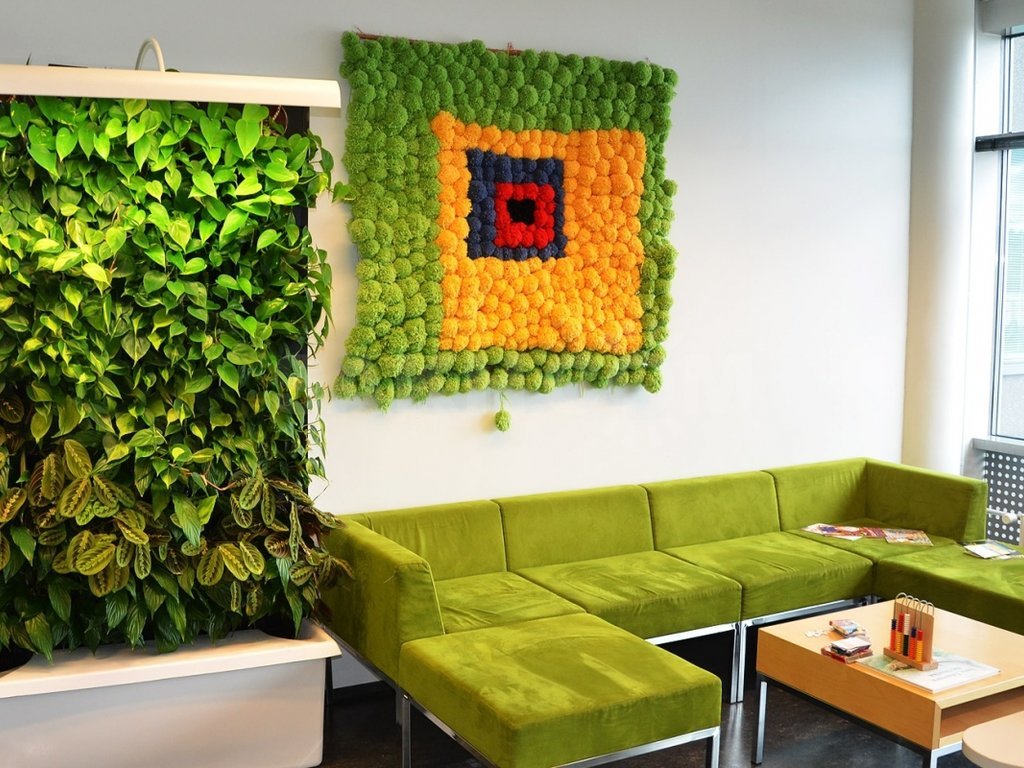 Obývací stěna v místnosti se zelenou pohovkou